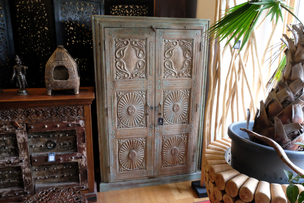 harmonischer schrank mit handgeschnitzten tueren und pastellgruener patina